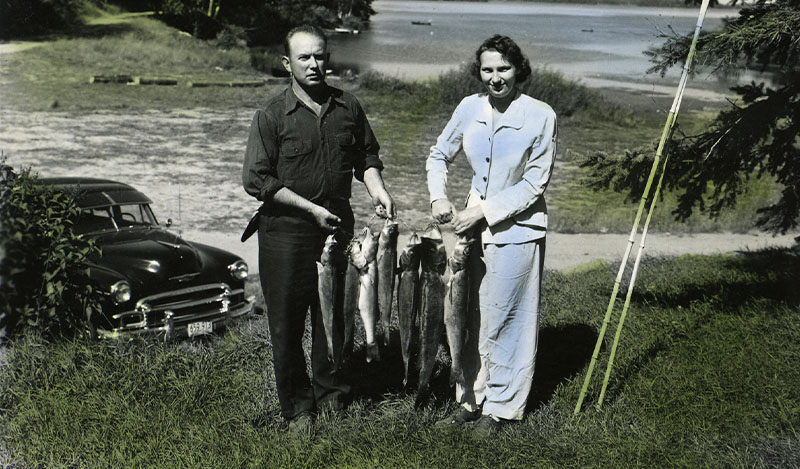 Historic photo of couple holding medium sized fish