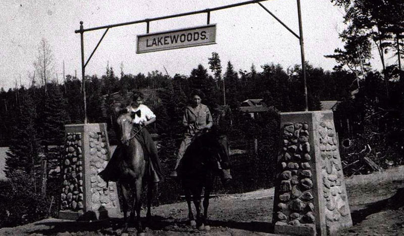 Historic photo of guests on horseback under Lakewoods sign.