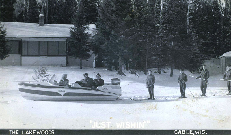 Historic photo of group on the frozen lake with a boat and water skis