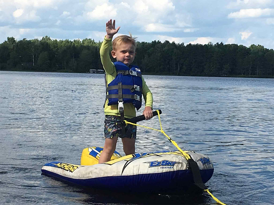 Young boy on a water ski inner tube