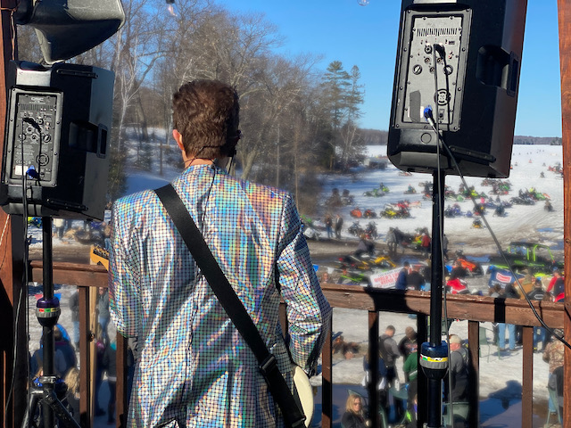 Musician playing guitar on deck overlooking the lake