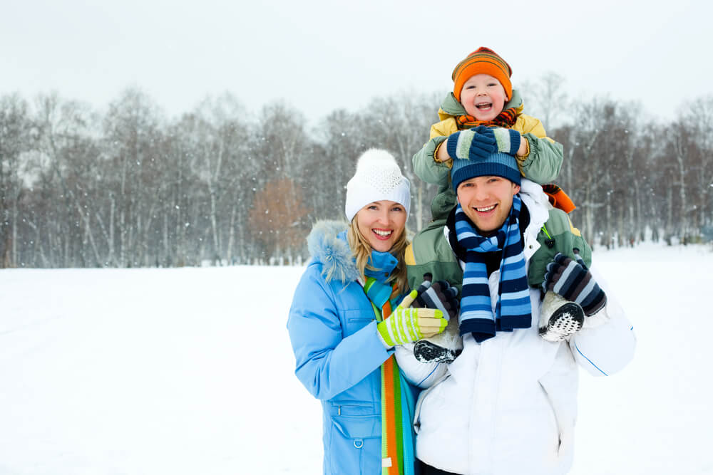 A family of three pose in the snowy winter during their vacation at Lakewoods Resort in Wisconsin.